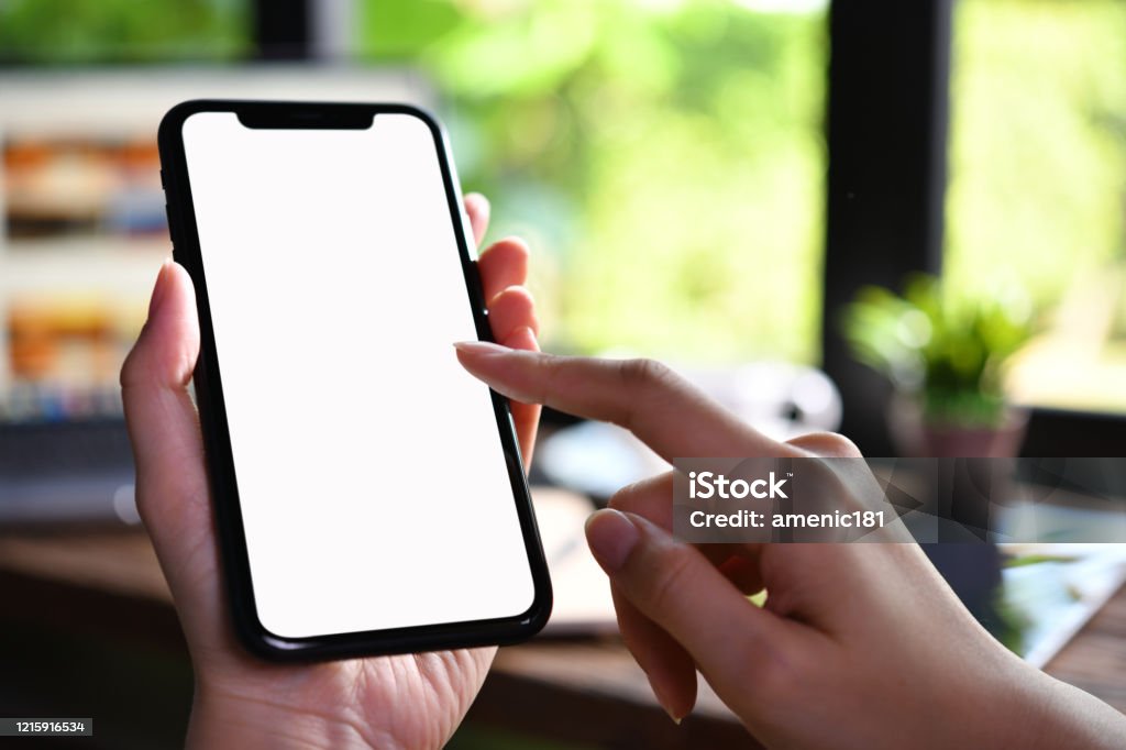 Close-up image of female hands using smartphone with blank white screen in the coffee shop Smart Phone Stock Photo
