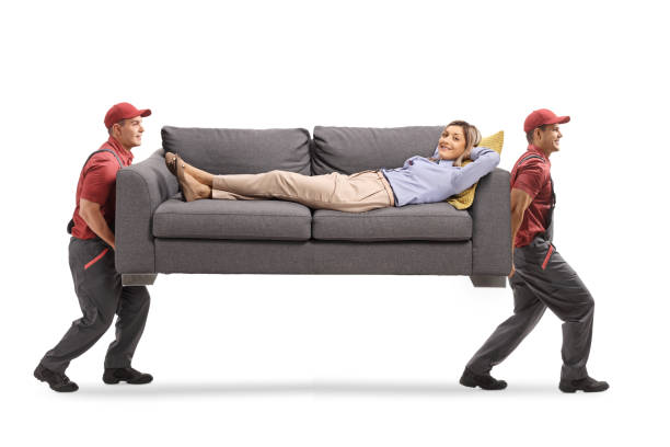 istock Movers carrying a sofa with a young woman lying 1215917182