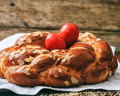Easter traditional sweet bread, greek tsoureki and red eggs closeup view. Orthodox Christian Easter tradition