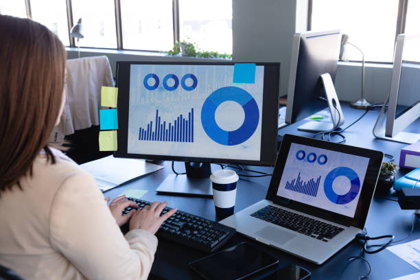 istock Caucasian woman working on computer with statistics on screens 1215917958