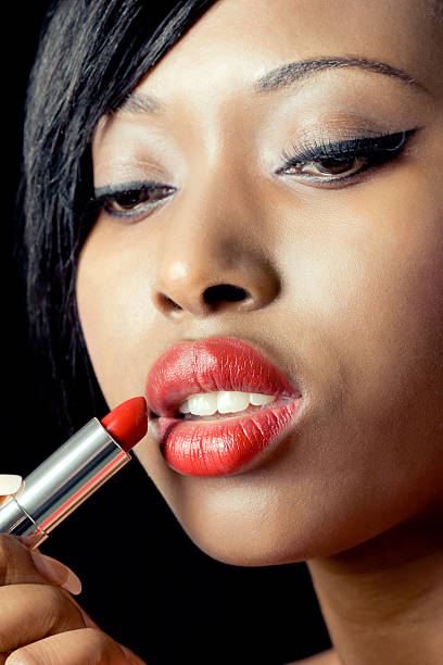 istock Beautiful woman applying lipstick 121591837