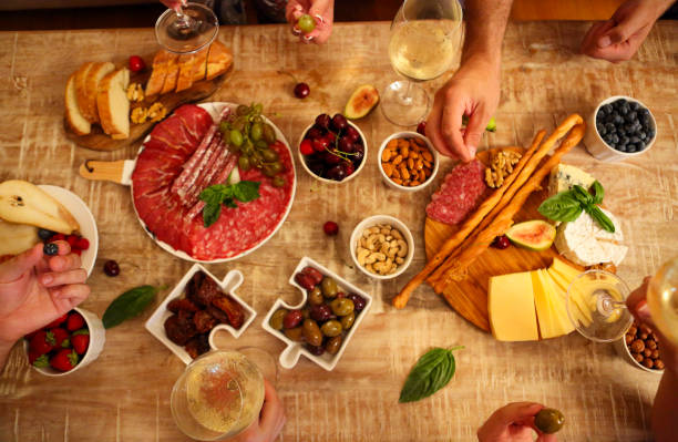 istock People cheering with white wine and rising glasses on celebration at restaurant 1215918982