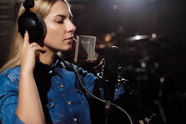 istock Blonde singing woman in a recording studio 1215919677