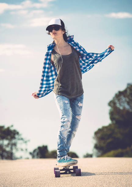 istock Young woman down the road with a skateboard 1215923741