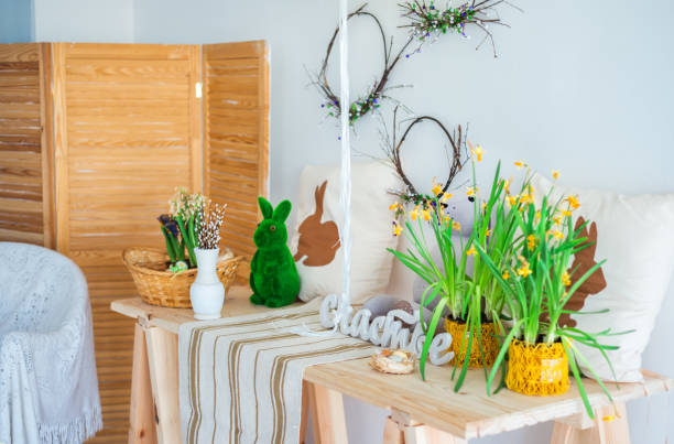 istock Easter home interior. Vase with pussy-willow twigs with a rabbit, daffodils on the table 1215923989