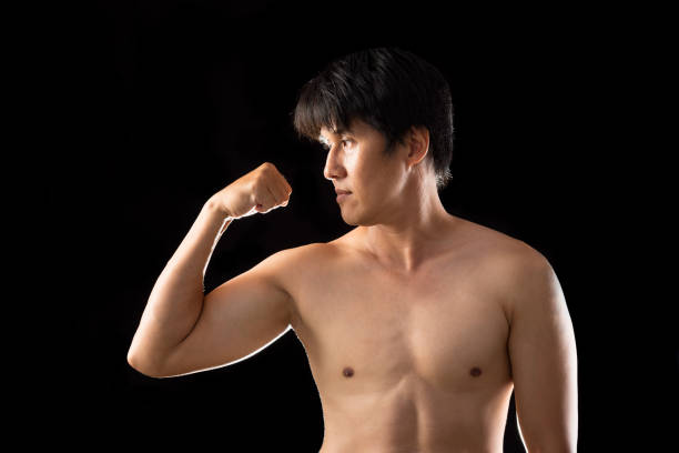 Muscle Boxer Shaped Asian Man raising right hand posting side view on black background