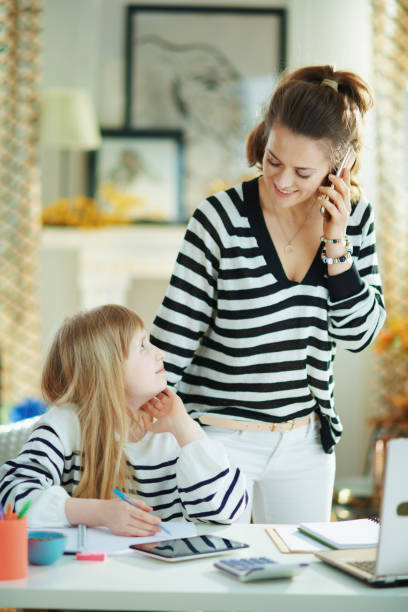 istock mother and working and helping child with homework 1215925696