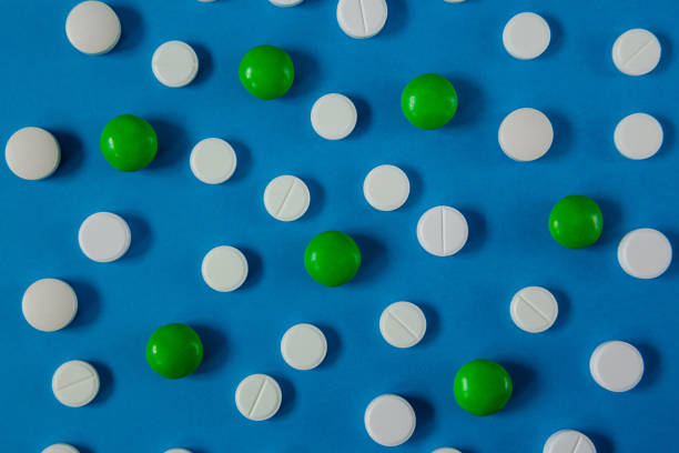 istock many white and red pills on a blue background 1215926503