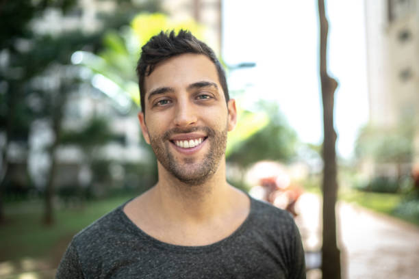 Portrait of smiling young man outdoors Portrait of smiling young man outdoors gay man photos stock pictures, royalty-free photos & images
