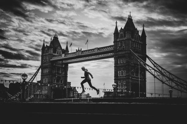 Alone runner in empty streets of london in Coronavirus, Covid-19 quarantine time. Tower Bridge in background Alone runner in empty streets of london in Coronavirus, Covid-19 quarantine time. Tower Bridge in background tower bridge london england bridge europe stock pictures, royalty-free photos & images