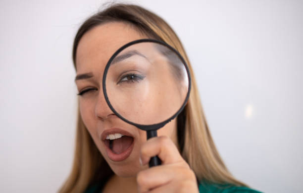 istock Woman looking through magnifying glass 1215930063