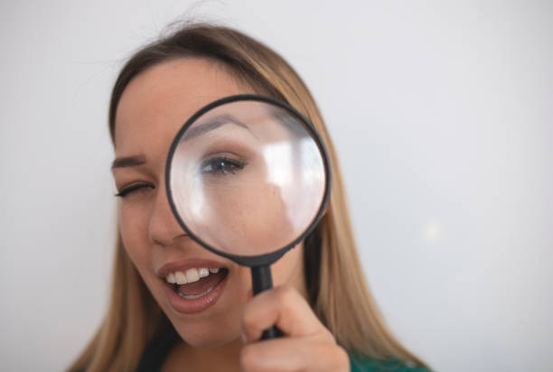 istock Woman looking through magnifying glass 1215930080