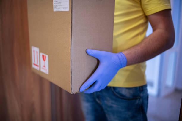 istock Man Delivering Parcel In A Pandemic 1215930911