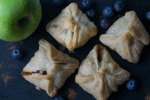 Mini apple pies with fresh apples and blueberries