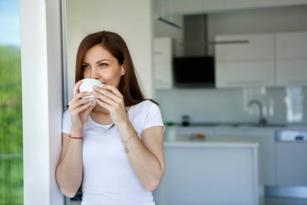 istock Young woman enjoying coffee at home 1215946112