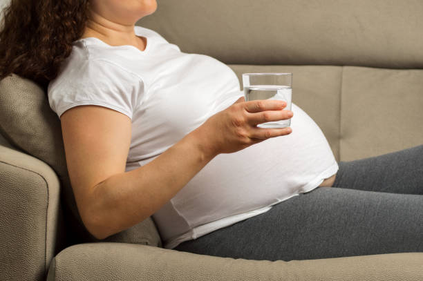 istock pregnant woman drinking water 1215946377