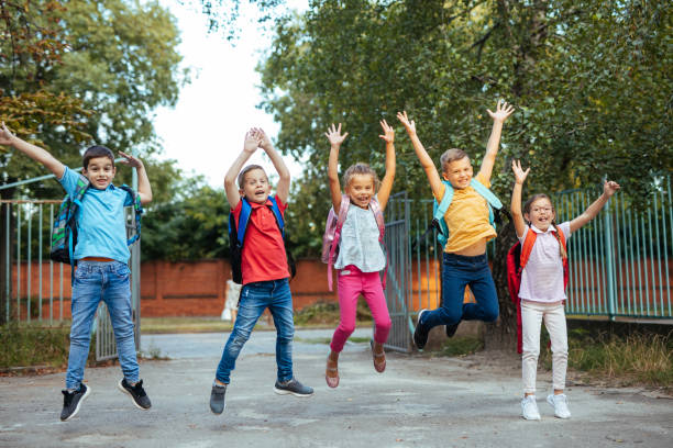 istock Five children jumping in the air wearing backpacks 1215946884