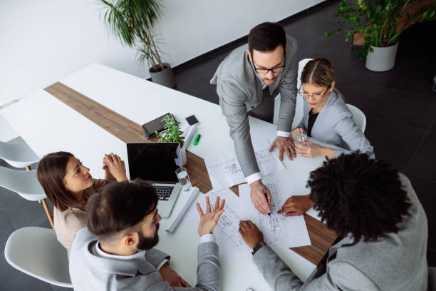 istock Multi ethnic group of architects working on plans in board room 1215947354