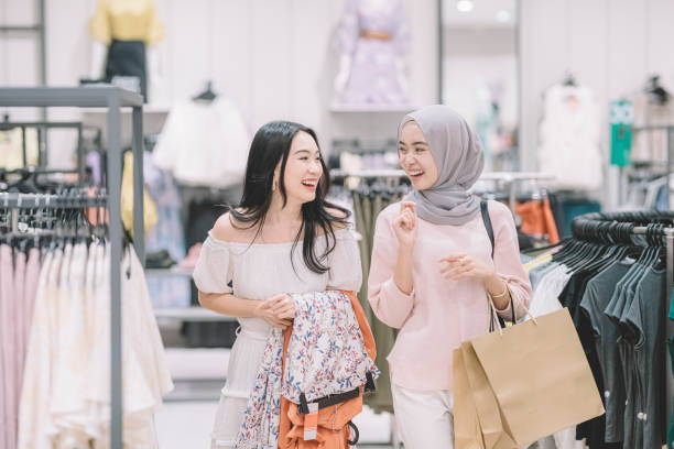 2 의류 상점에서 쇼핑과 구매 드레스 새로운 옷을 결정에 시도 하는 중국과 말레이시아 여성 - clothing store clothing sale fashion 뉴스 사진 이미지