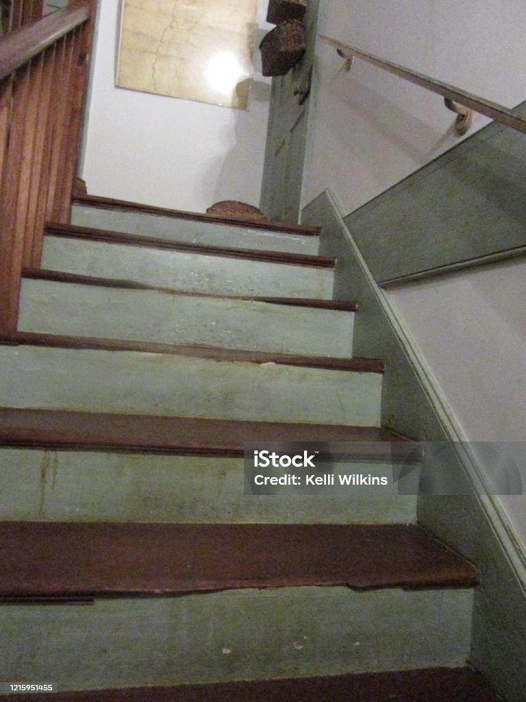 Wooden staircase in old house A worn, wooden staircase leading up to a door in an old farmhouse. Antique Stock Photo