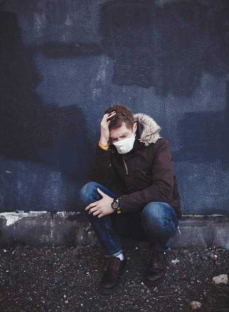 istock sick man with a coronavirus sits in a mask 1215951531