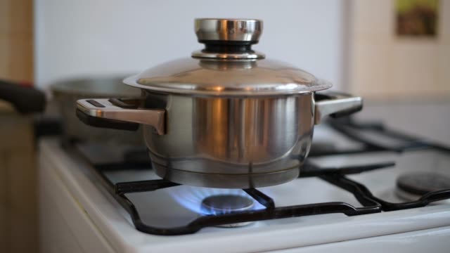 Primer plano de una olla para cocinar arroz en un quemador de gas