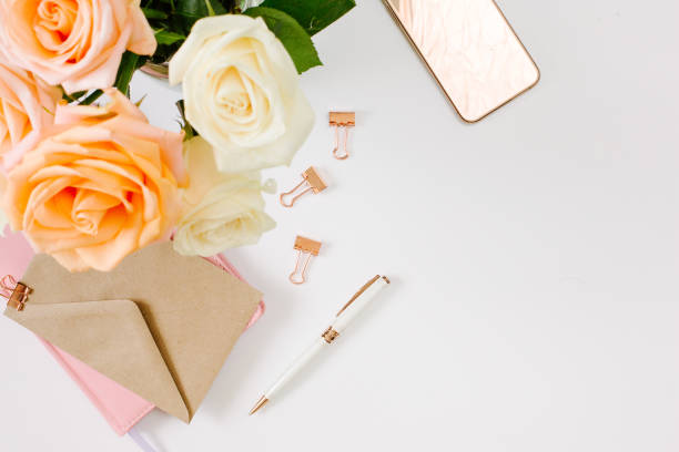 istock Blogging at home with beautiful roses and pink notebook on white background. 1215953125