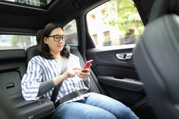 istock Woman using a smart phone in a car 1215953679