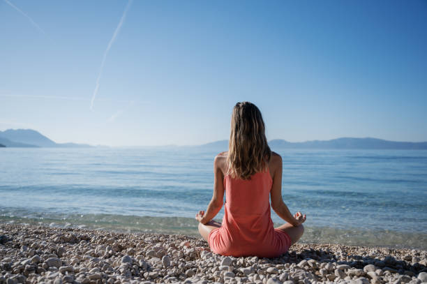 istock Woman meditating on the beach 1215955473