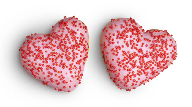 istock Pink heart doughnuts with sprinkles on white 1215955925