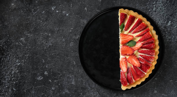 A half of fresh strawberry flan on black background A half of fresh strawberry cake on black background. Copy space halved stock pictures, royalty-free photos & images