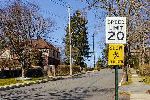 Road sign displaying 20 mph speed limit near the school or kindergarten in the American neighborhood