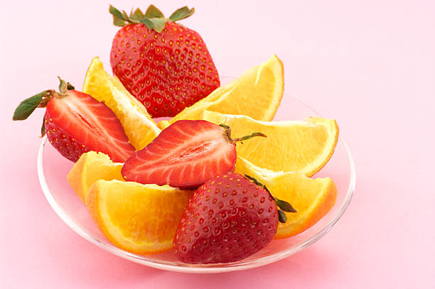 Front view of three glasses with orange juice, strawberry juice and kiwi juice isolated on white background. The composition is at the left of an horizontal frame leaving useful copy space for text and/or logo at the right. High resolution 42Mp studio digital capture taken with SONY A7rII and Zeiss Batis 40mm F2.0 CF lens