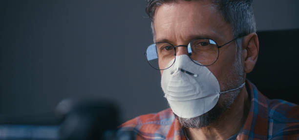 istock Man in face mask having video call 1215971352