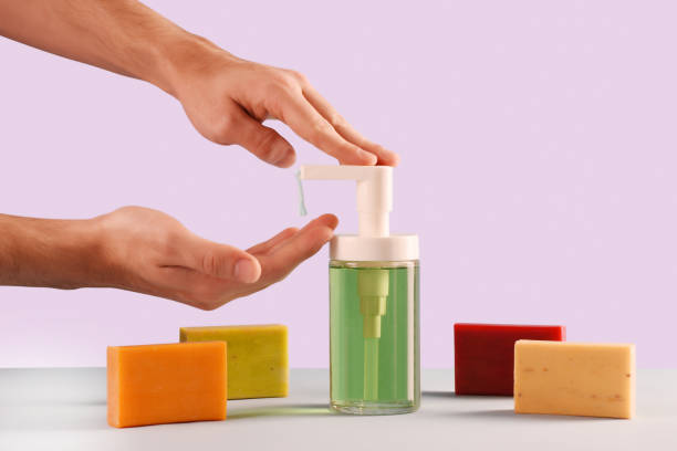 Concept of soaps, a male hands using soap dispenser and multi colored soap bars