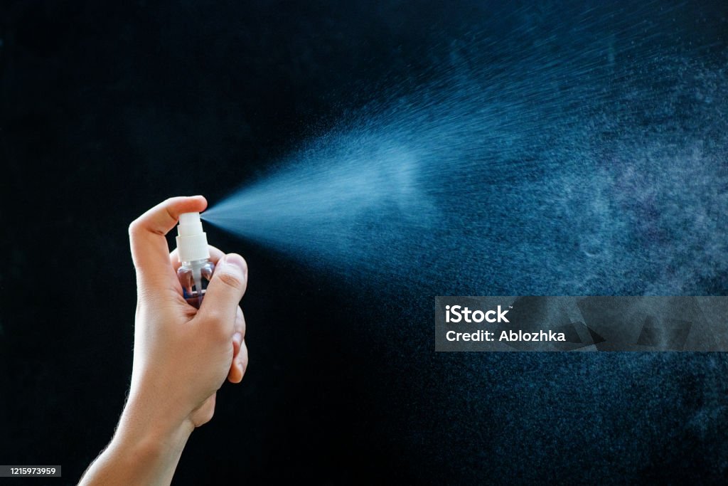 Close up of using antibacterial hand spray on black background Close up of using antibacterial hand spray on black background. Healthcare and hygiene concept. Spray Stock Photo