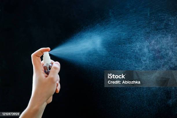 Close Up Of Using Antibacterial Hand Spray On Black Background Stock Photo - Download Image Now