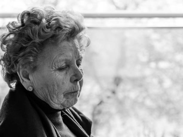 istock Elderly woman sitting by the window 1215974527