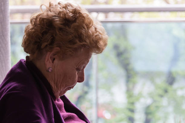 istock Elderly woman sitting by the window 1215974530