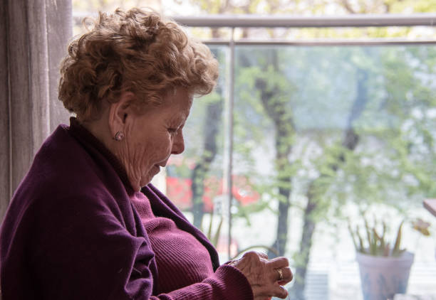 Belgrade, Serbia - June 11, 2017: Senior woman looking out of the opened apartment window