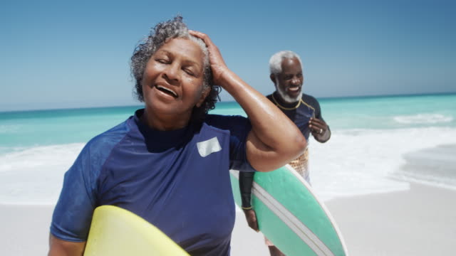 Senior couple with surfboards at the beach