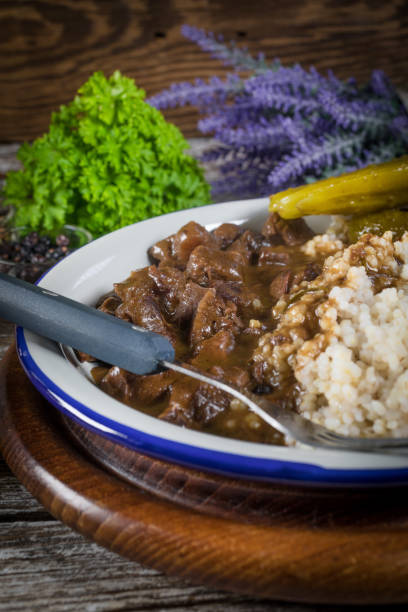 istock Beef stew served with barley and pickled cucumber. 1215975693