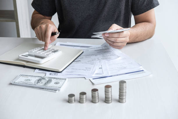 Images of stacking coin pile and Husband using calculator to calculating expenditure receipt bills of various activity cost and expenses in home office and written make report to plan of spent. imágenes de apilamiento de la pila de monedas y marido utilizando calculadora para calcular las facturas de recibo de gastos de diversos costos y gastos de actividad en la oficina en casa y por escrito hacer informe para planificar el gasto