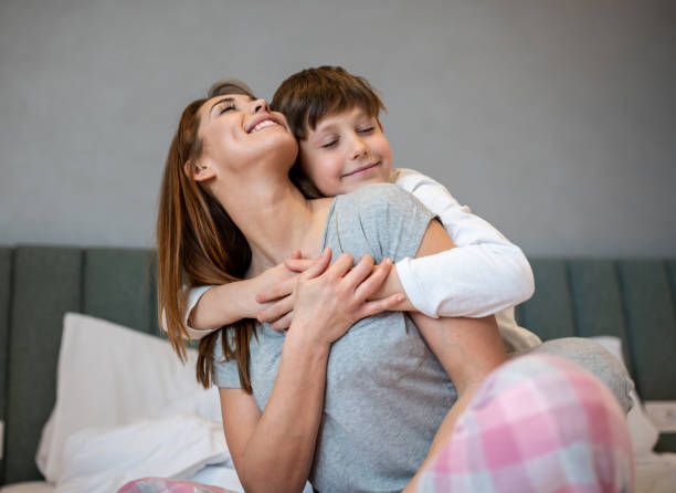 istock Son hugging her own mother whilst smiling. 1215979665