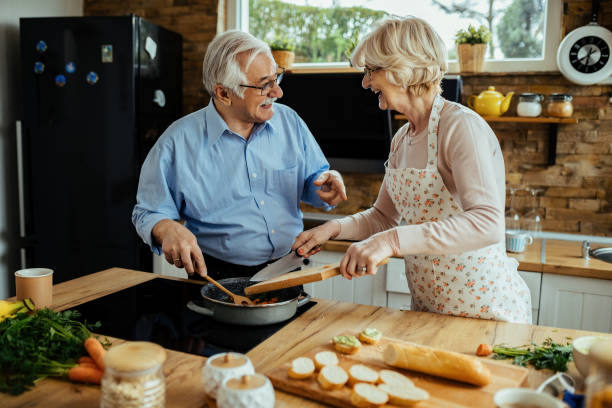 istock Cheerful senior couple having fun while preparing food in the kitchen. 1215981655