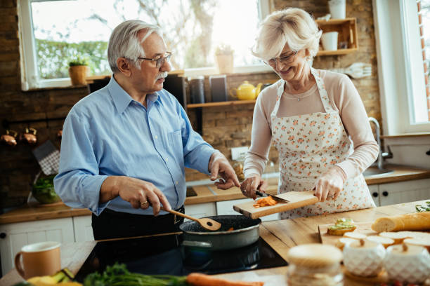 istock Senior couple enjoying while preparing meal together in the kitchen. 1215981661