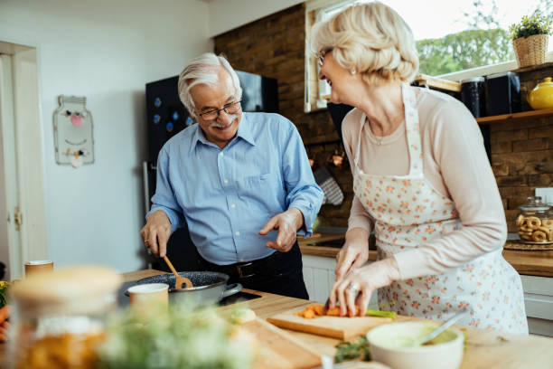 istock Happy mature couple having fun while cooking lunch in the kitchen. 1215981736