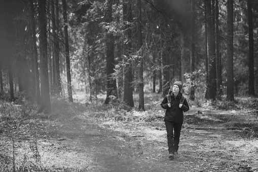 Black and White image of Young woman walking in spring forest