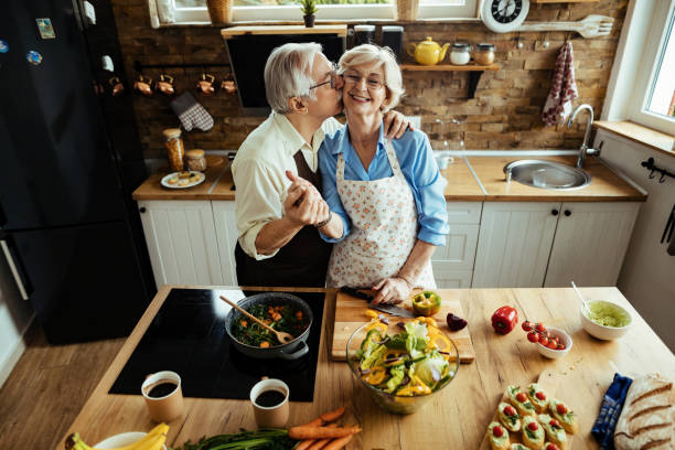 istock Happy mature couple showing affection while preparing healthy food in the kitchen. 1215984471