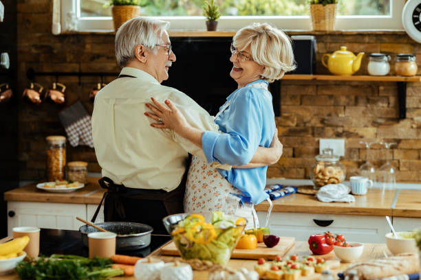 istock Happy senior couple talking while dancing in the kitchen. 1215985308